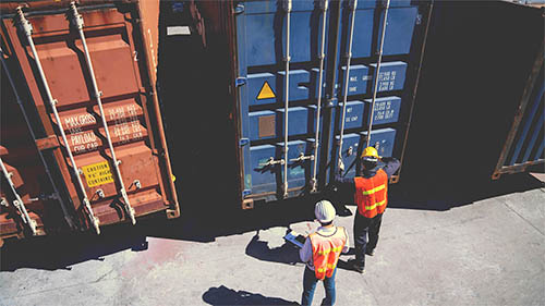 Workers checking freight containers